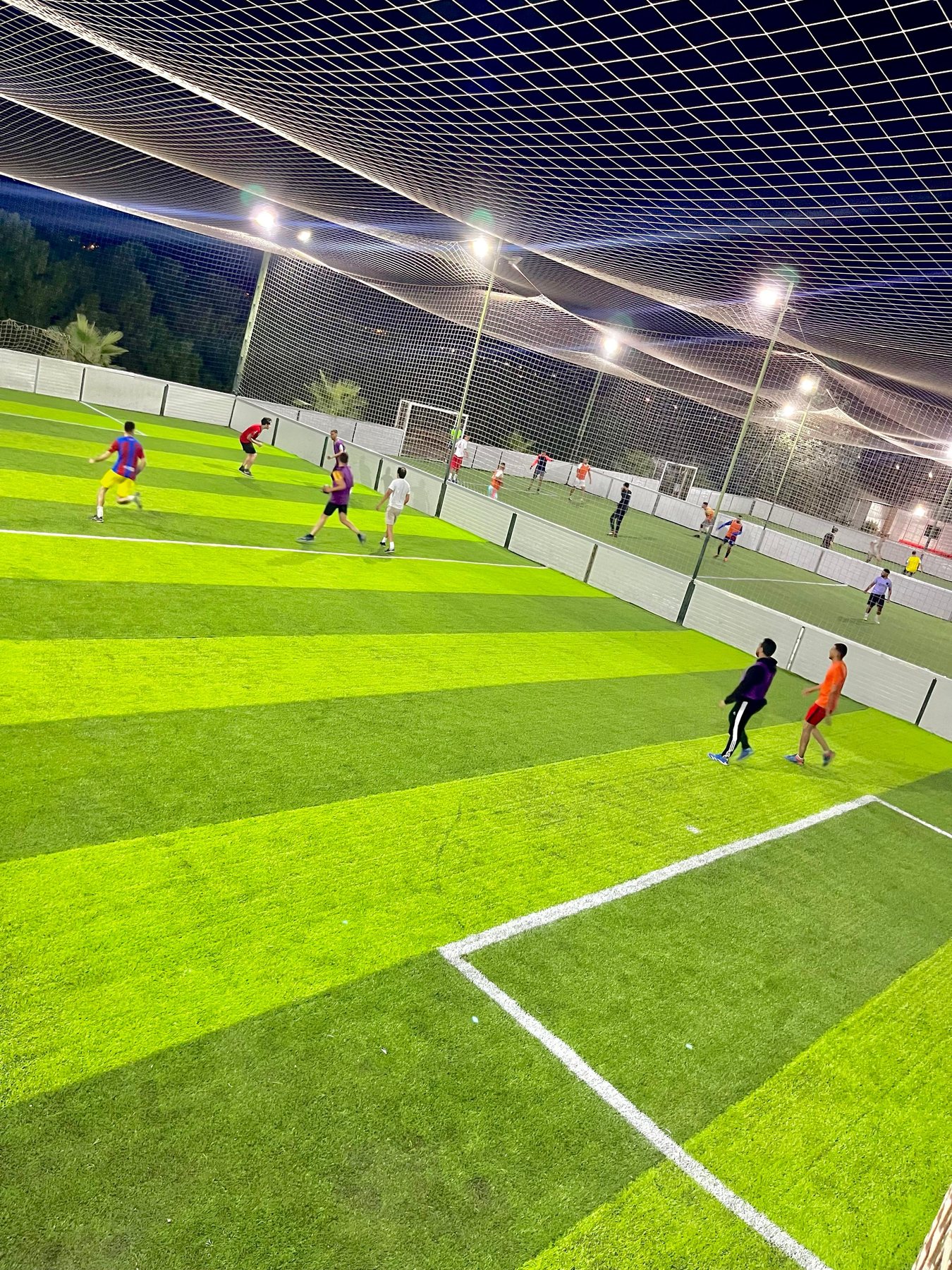 Un match de Foot 5 en soirée sur un terrain éclairé